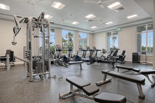 gym with a paneled ceiling, baseboards, and visible vents