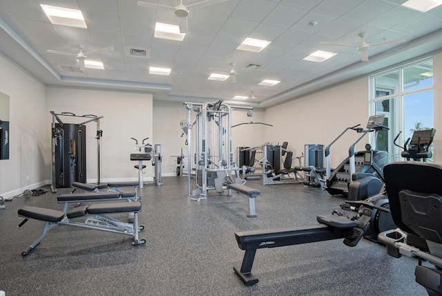 exercise room featuring baseboards, a paneled ceiling, visible vents, and a ceiling fan