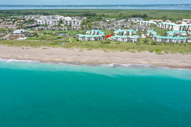 birds eye view of property featuring a water view and a beach view