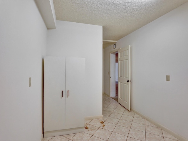 interior space with light tile flooring and a textured ceiling