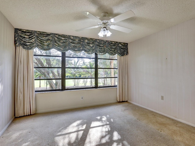 carpeted empty room with ceiling fan and a textured ceiling