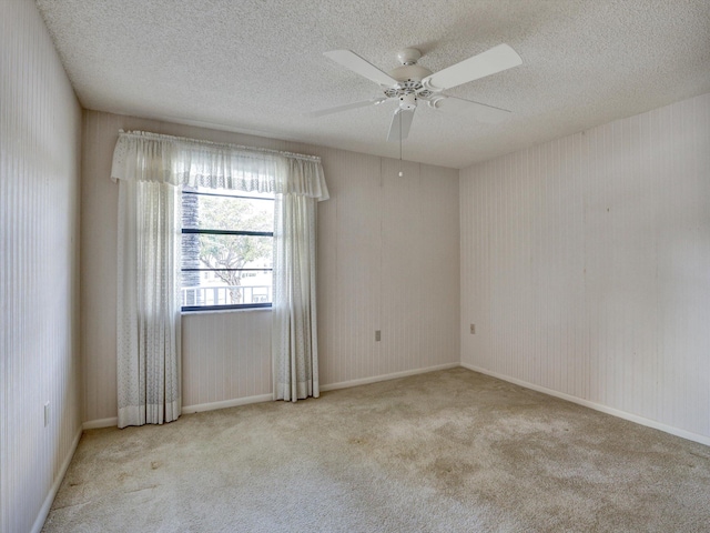 carpeted empty room featuring ceiling fan and a textured ceiling