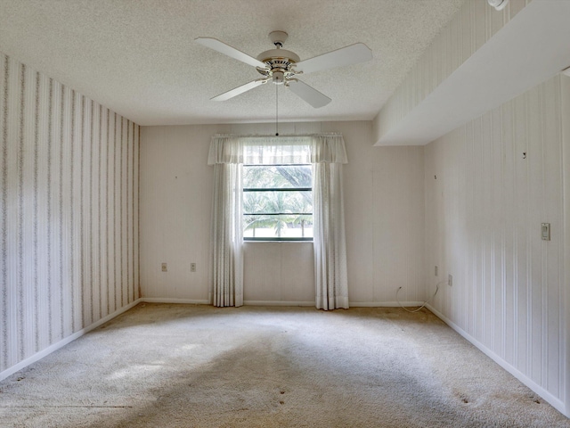 carpeted spare room featuring ceiling fan and a textured ceiling