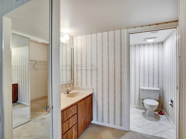 bathroom with toilet, tile floors, and vanity