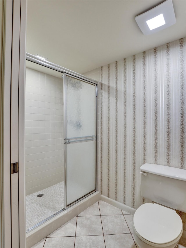 bathroom featuring tile flooring, a shower with door, and toilet