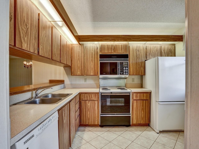 kitchen with a textured ceiling, sink, white appliances, light tile flooring, and a chandelier