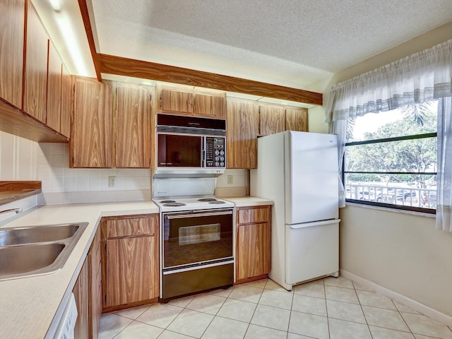 kitchen with white appliances, light tile flooring, a textured ceiling, tasteful backsplash, and sink