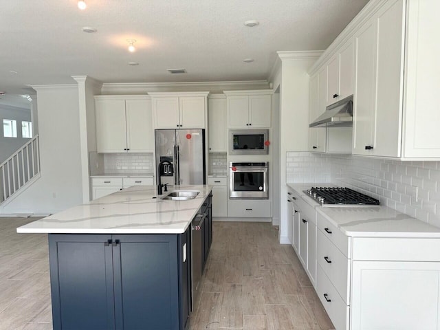 kitchen with white cabinets, sink, an island with sink, light hardwood / wood-style floors, and stainless steel appliances