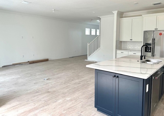 kitchen with sink, light hardwood / wood-style flooring, stainless steel fridge, light stone countertops, and white cabinetry