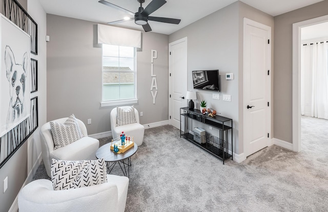 sitting room with ceiling fan and light colored carpet