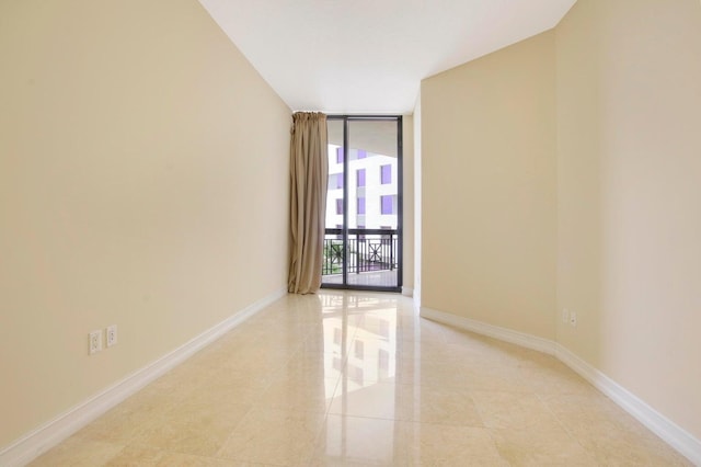 tiled spare room with a wall of windows