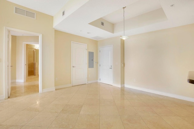 unfurnished room featuring light tile patterned flooring, electric panel, and a raised ceiling