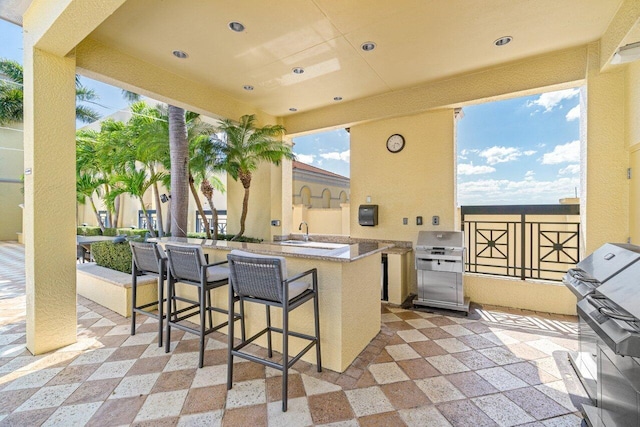 view of patio / terrace with a wet bar, area for grilling, and a grill