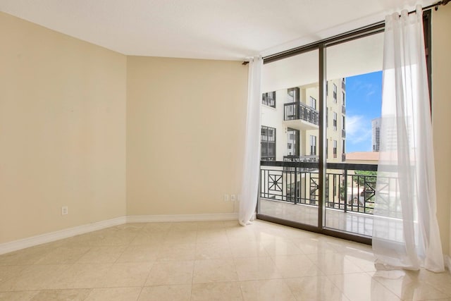 tiled spare room with expansive windows and baseboards