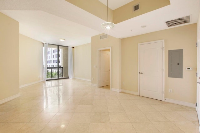 spare room with electric panel, light tile patterned flooring, and floor to ceiling windows