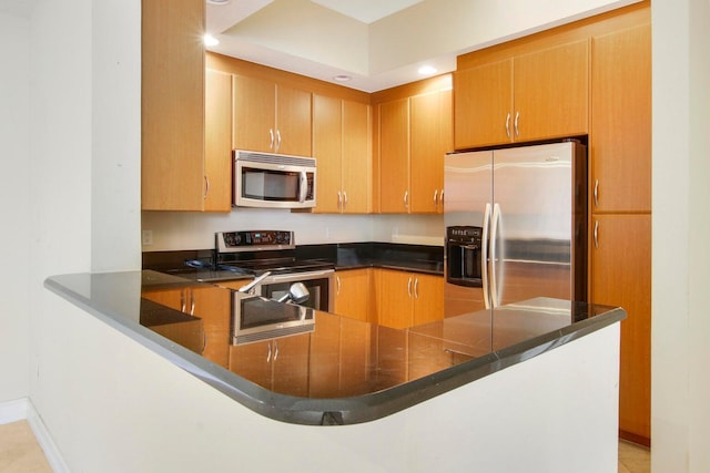 kitchen with light tile patterned floors, stainless steel appliances, and kitchen peninsula