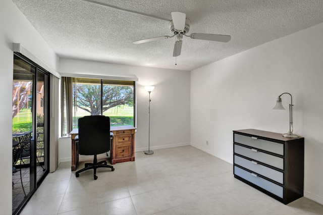 tiled office space featuring a textured ceiling and ceiling fan