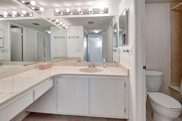 bathroom featuring a textured ceiling, vanity, and toilet