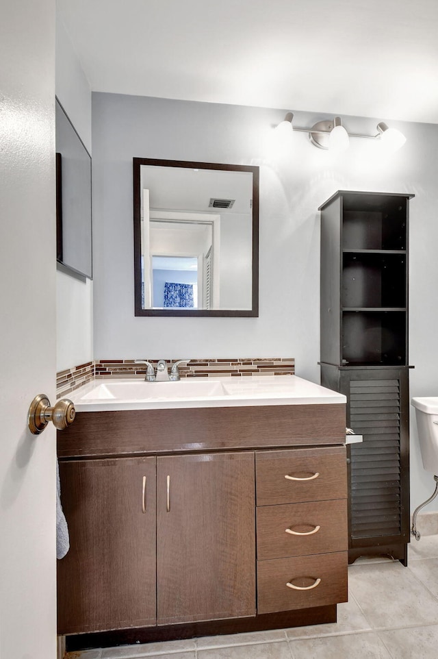 bathroom with vanity, toilet, and tile flooring