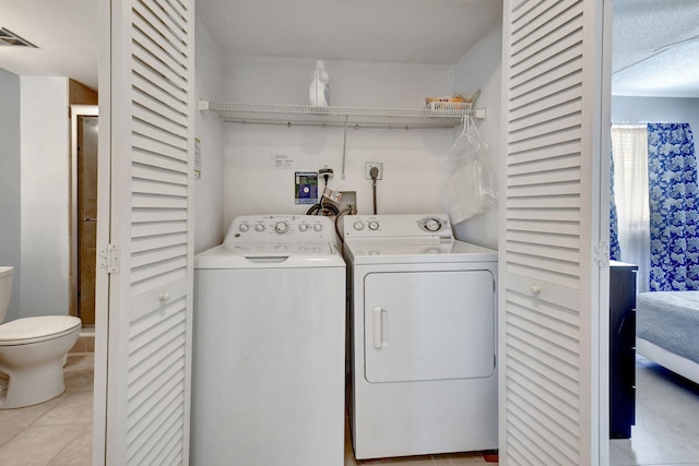 clothes washing area with washer hookup, hookup for an electric dryer, washing machine and dryer, and light tile floors