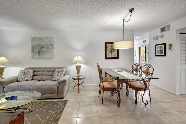 tiled dining space with a textured ceiling