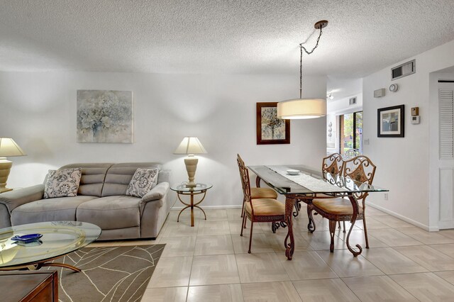 dining room featuring light tile floors and a textured ceiling