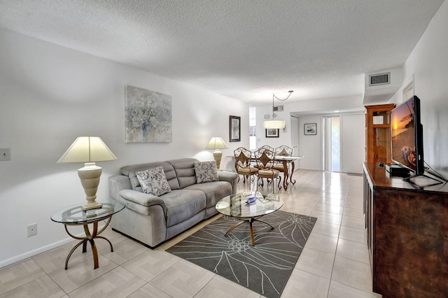 tiled living room featuring a textured ceiling