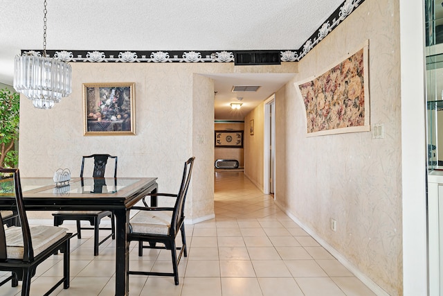 dining room with a textured ceiling, an inviting chandelier, and light tile floors