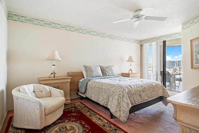 bedroom featuring ceiling fan, access to exterior, and a textured ceiling