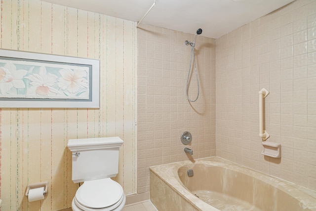 bathroom featuring tile floors, toilet, and tiled shower / bath