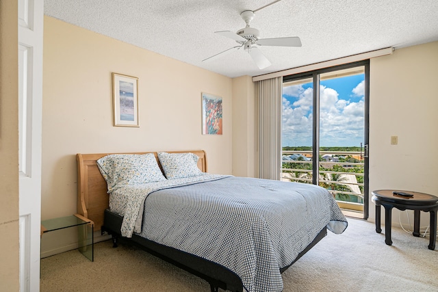 carpeted bedroom featuring ceiling fan and a textured ceiling