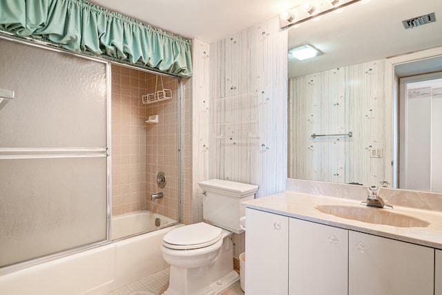 full bathroom featuring tile floors, toilet, bath / shower combo with glass door, and vanity