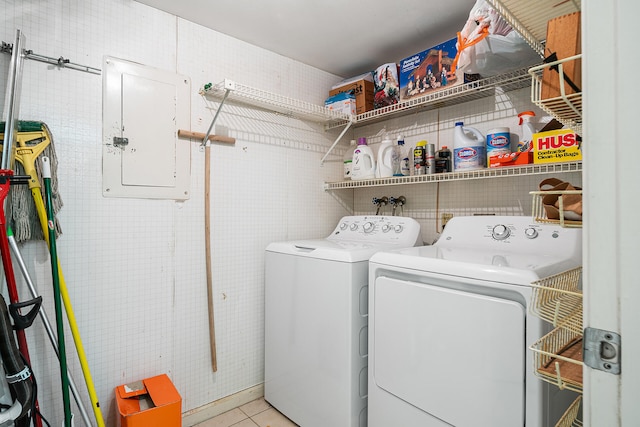 clothes washing area featuring hookup for a washing machine, light tile floors, and washing machine and clothes dryer