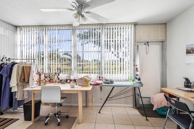 tiled home office with ceiling fan and a textured ceiling