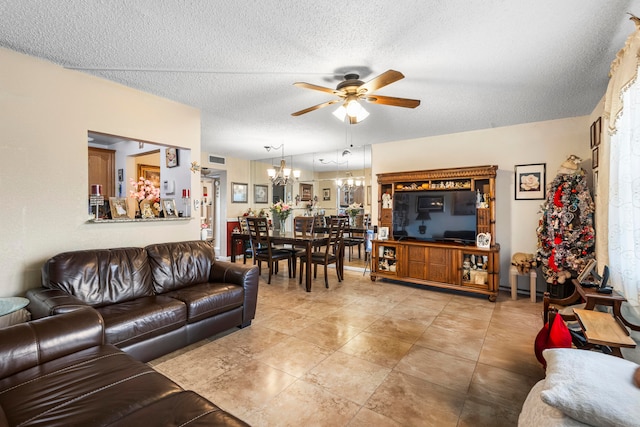 tiled living room featuring ceiling fan with notable chandelier and a textured ceiling