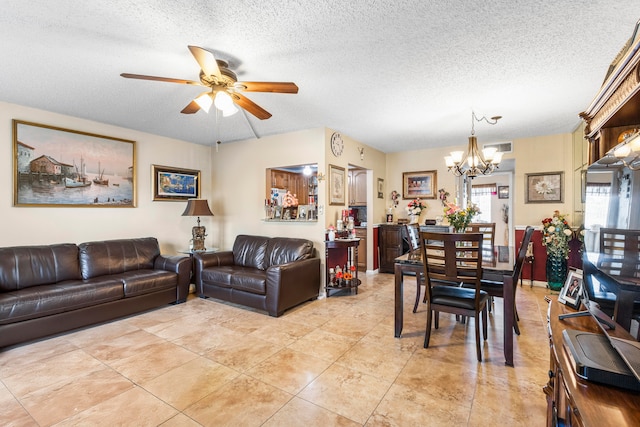 living room with light tile flooring, ceiling fan with notable chandelier, and a textured ceiling