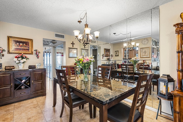 tiled dining space with a chandelier and a textured ceiling