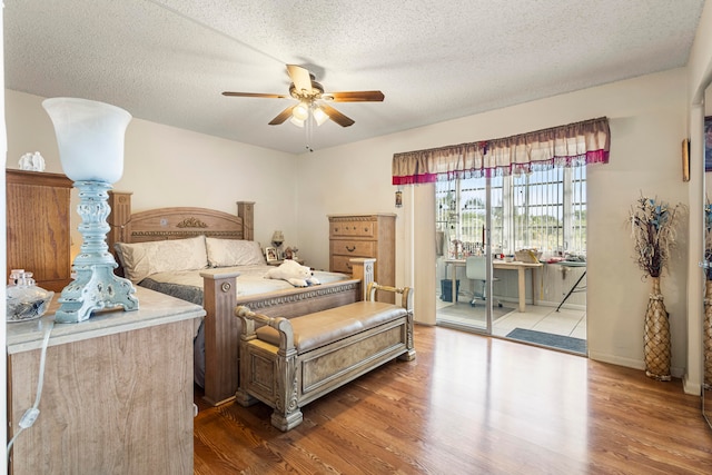 bedroom featuring hardwood / wood-style flooring, ceiling fan, and a textured ceiling