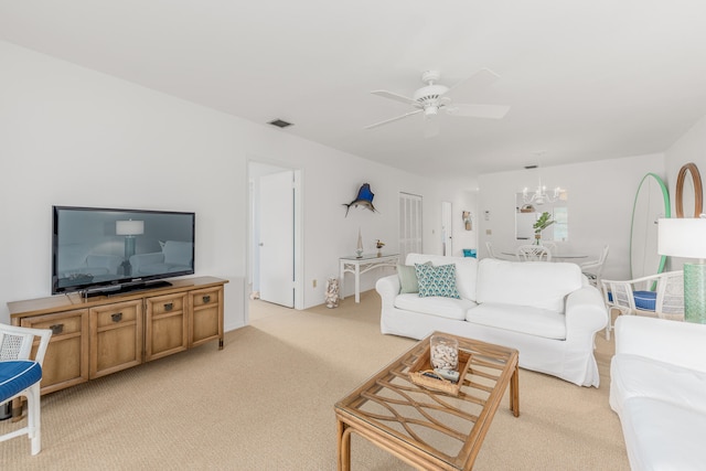 living room with light colored carpet and ceiling fan with notable chandelier