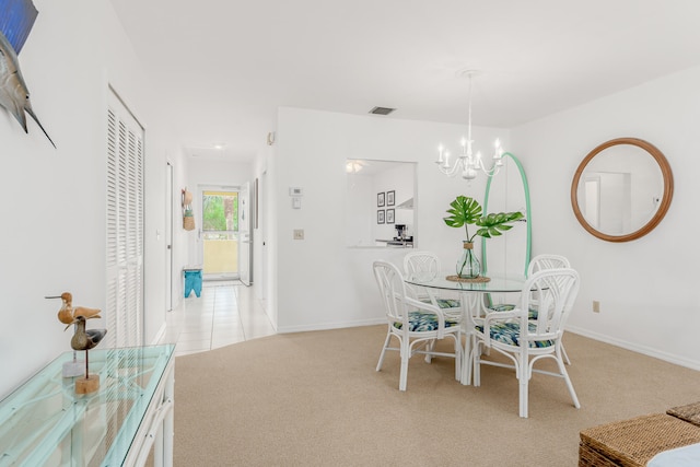 dining area with light carpet and a notable chandelier