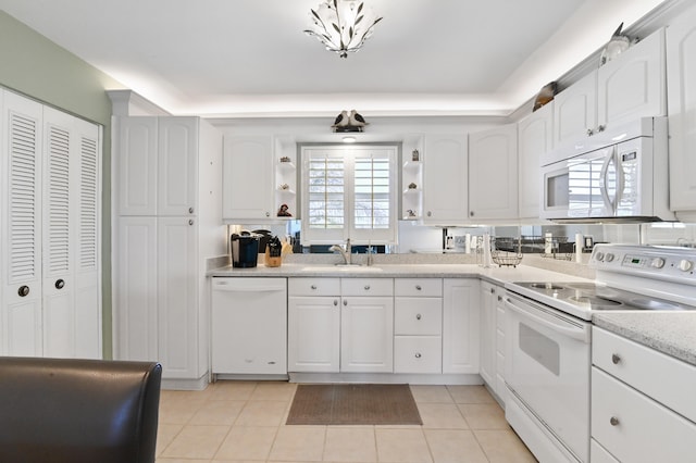 kitchen with light tile patterned floors, sink, white appliances, and white cabinetry