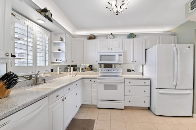 kitchen with white appliances, sink, light tile patterned floors, and white cabinets