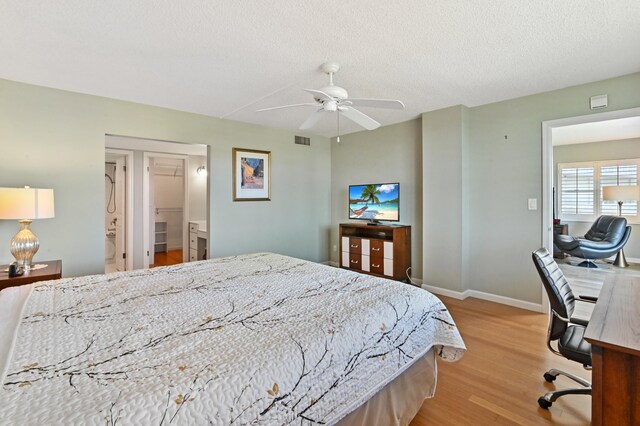 bedroom with ceiling fan, a textured ceiling, and light hardwood / wood-style floors