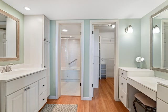 bathroom with walk in shower, vanity, and hardwood / wood-style flooring