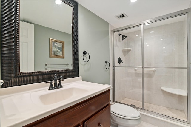 bathroom featuring vanity, toilet, and a shower with door