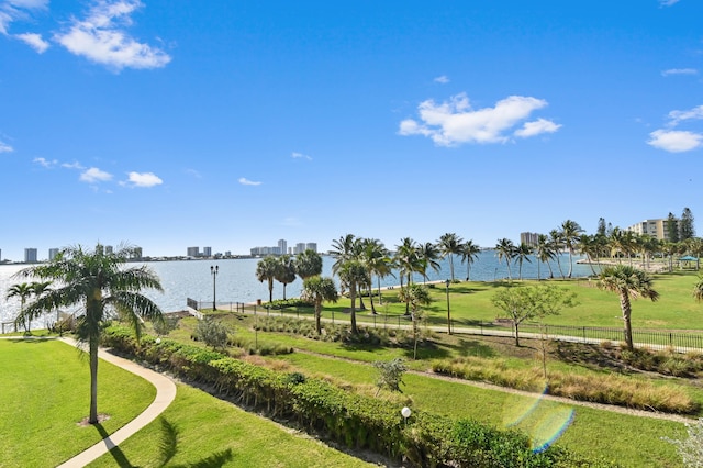 view of home's community with a water view and a yard