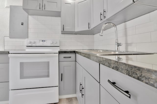 kitchen featuring backsplash, white electric stove, light hardwood / wood-style floors, and white cabinetry