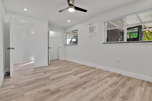 spare room featuring light hardwood / wood-style floors, a healthy amount of sunlight, and an AC wall unit