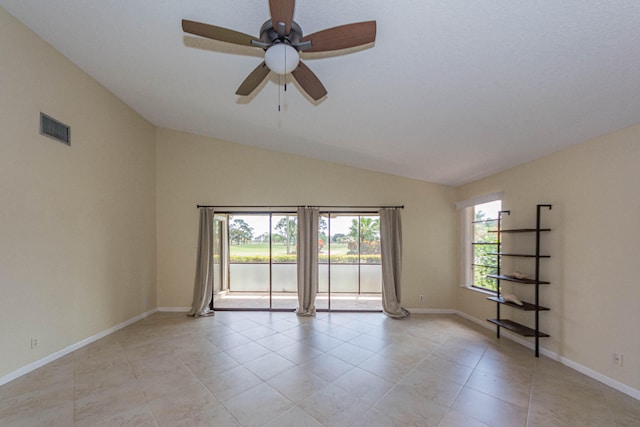 tiled empty room featuring vaulted ceiling and ceiling fan