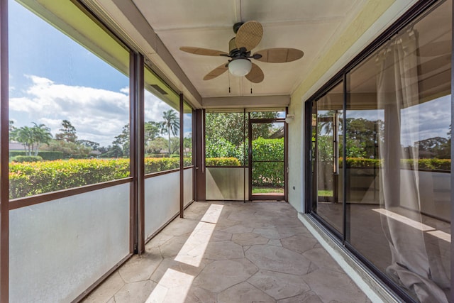 unfurnished sunroom featuring ceiling fan